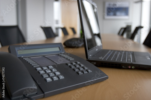 Bürotelefon und Laptop in einem Konferenzzimmer
