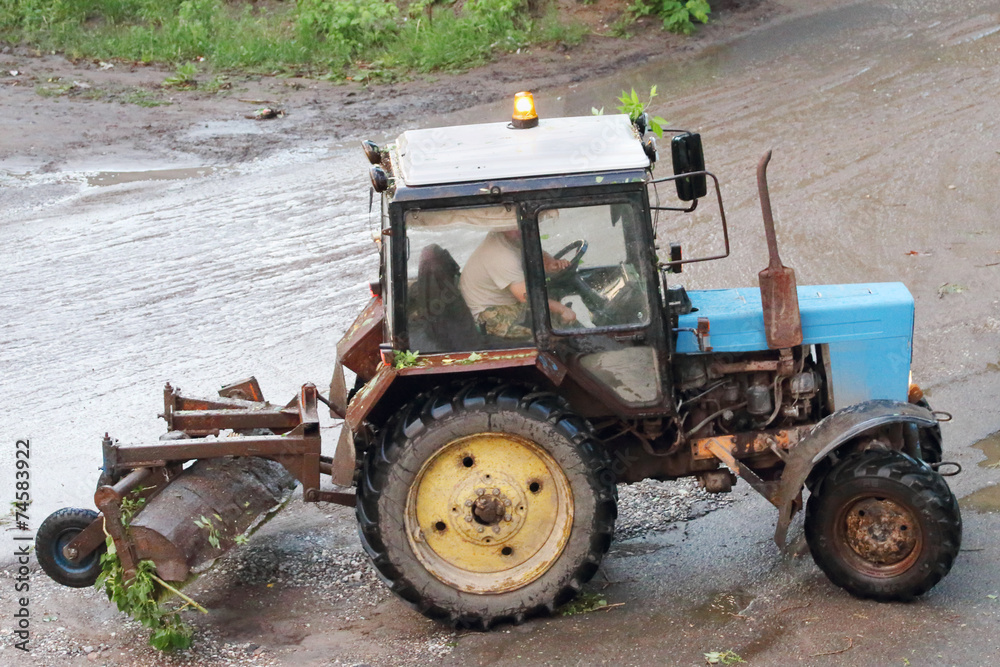 Blue old and rusty tractor running after rain storms and summer Blue old and rusty tractor running after rain storms and summer