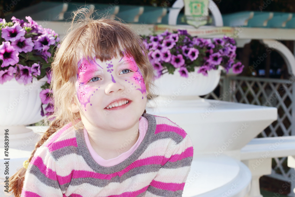 Happy little girl with pictured purple butterfly on face Happy little girl with pictured purple butterfly on face