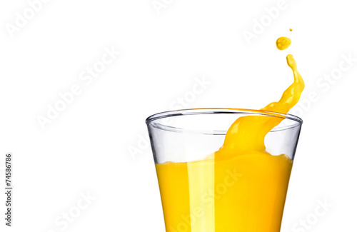 Splashing orange juice in glass on white background