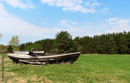 The old wooden boat laying in the field