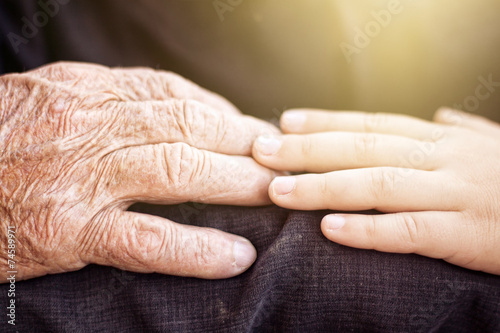 nephew touching grandfather's hand photo