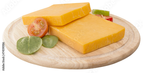 two slices of cheddar on wooden board decorated with cherry and