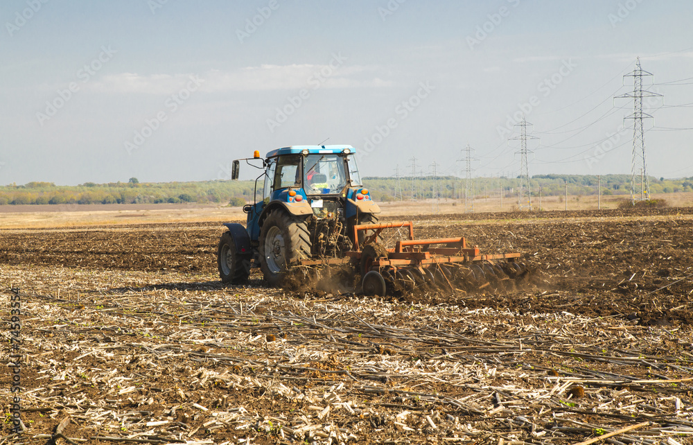 Fototapeta premium Farmer in tractor preparing land for sowing
