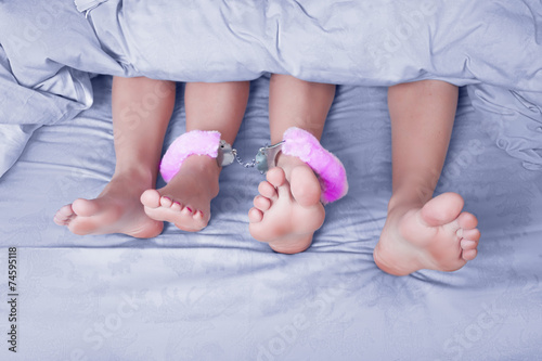 male and female legs handcuffed, sex toy. blue