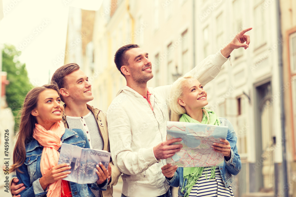 group of smiling friends with city guide and map