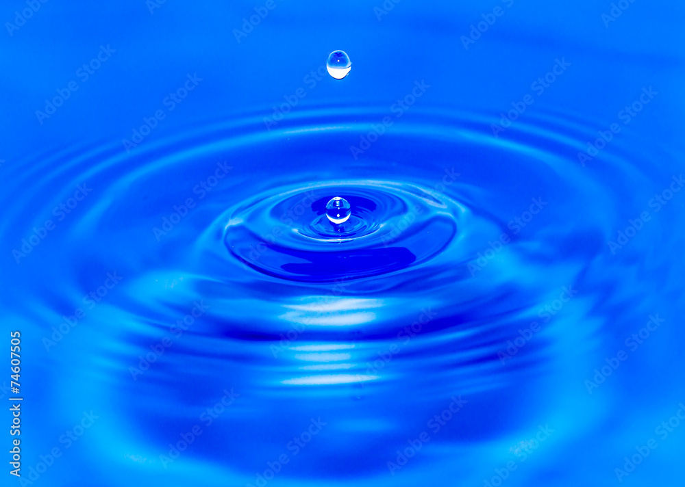 water droplets falling in blue water water droplets falling in blue water