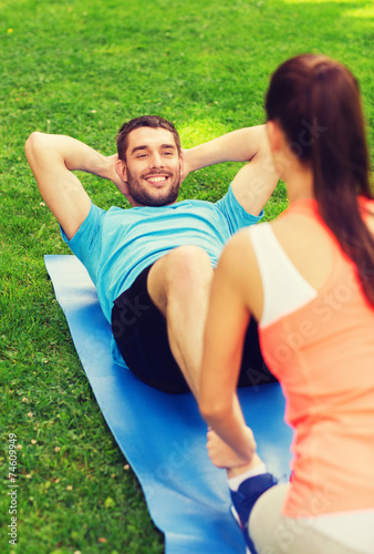 smiling man doing exercises on mat outdoors