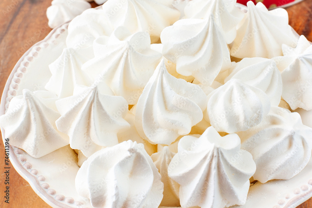 Porcelain plate full of many fluffy white meringue Porcelain plate full of many fluffy white meringue