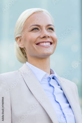 young smiling businesswoman over office building