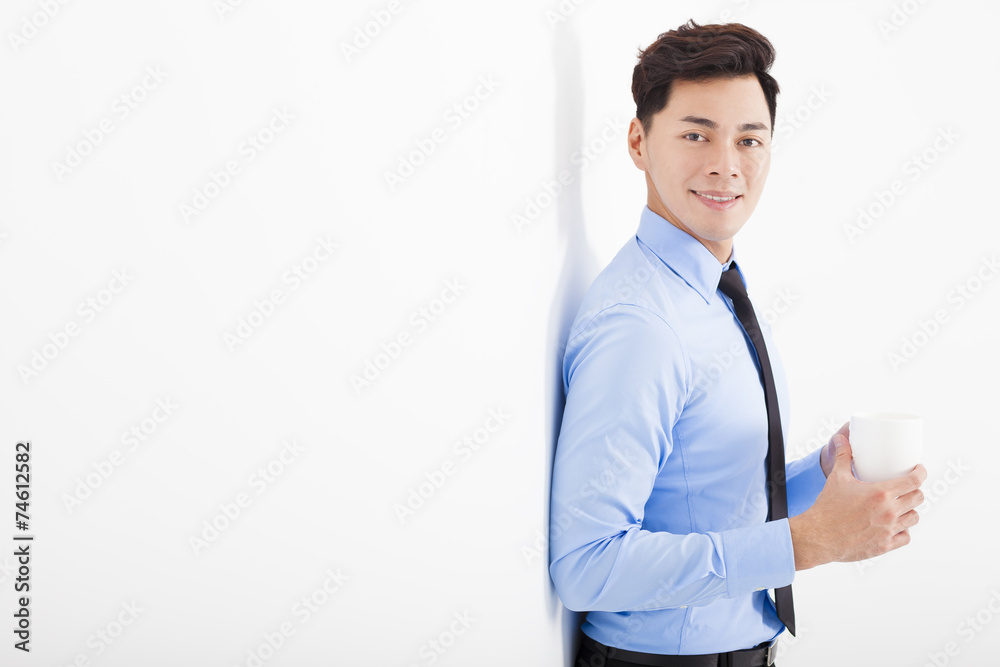 relaxed businessman leaning against white wall in office relaxed businessman leaning against white wall in office