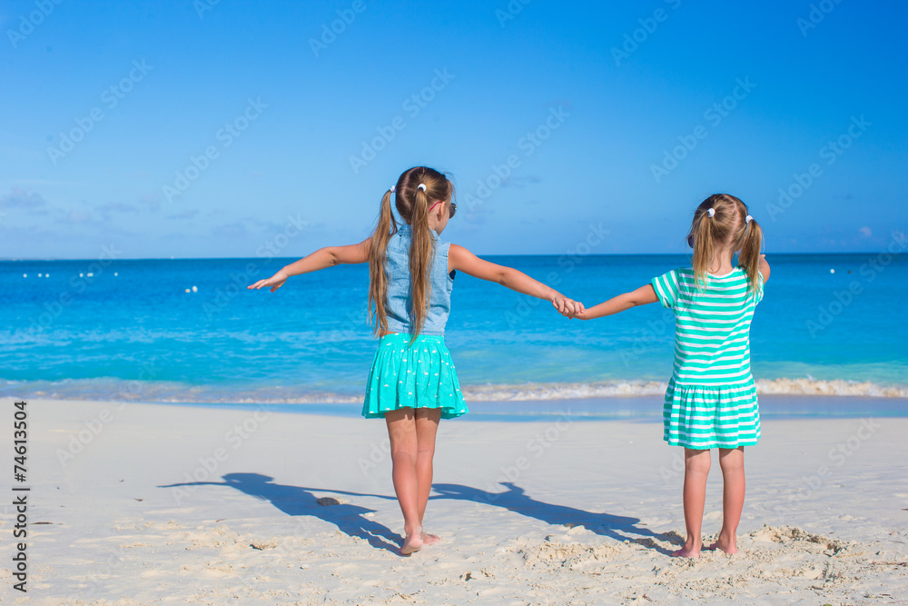Back view of little girls enjoying summer beach vacation