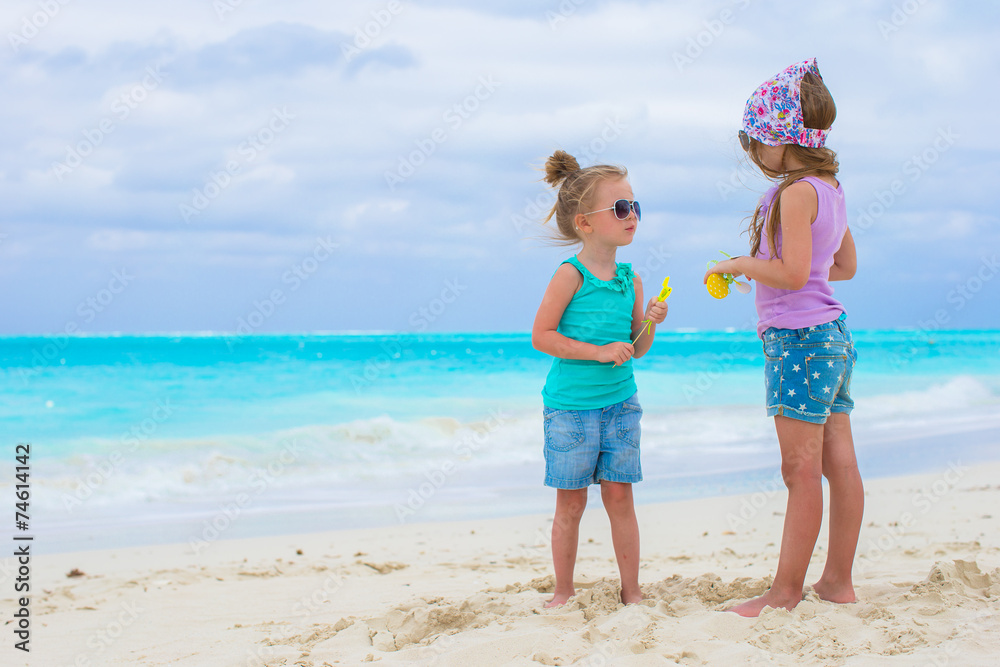 Little adorable girls on white tropical beach