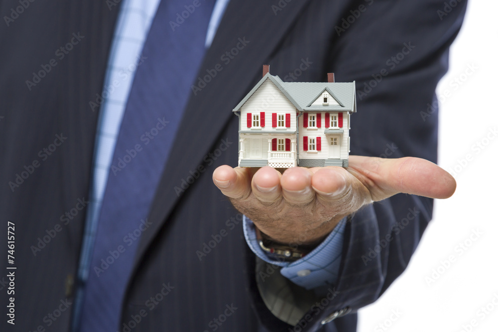 Male Real Estate Agent Holding Miniature House in Palm Male Real Estate Agent Holding Miniature House in Palm