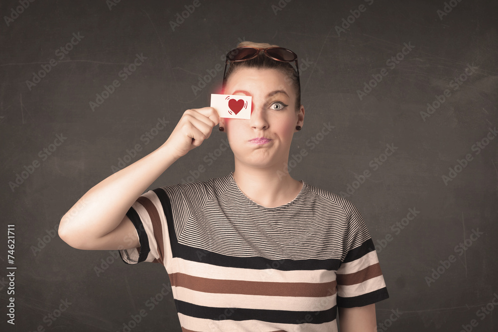 Pretty girl holding paper with red heart drawing Pretty girl holding paper with red heart drawing