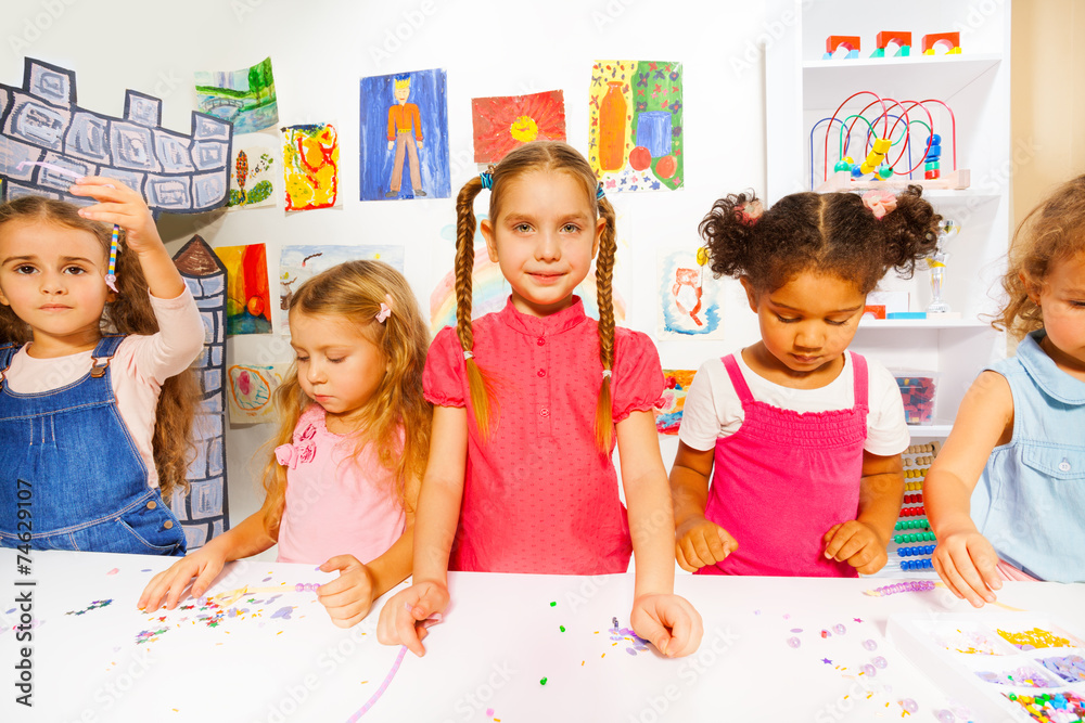 Fototapeta premium Happy little kids girls with beads in the class