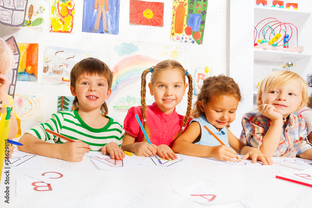 Fototapeta premium Boys and girls drawing letters in writing lesson