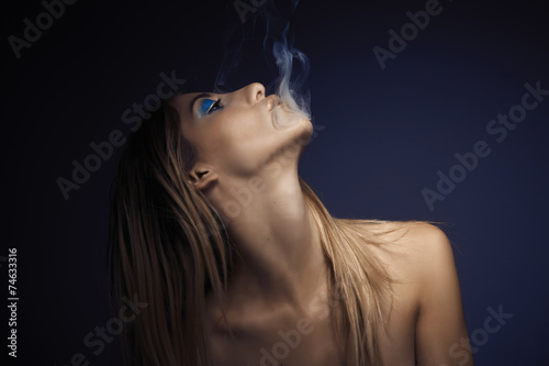 Portrait of young sexy woman while smoking cigarette