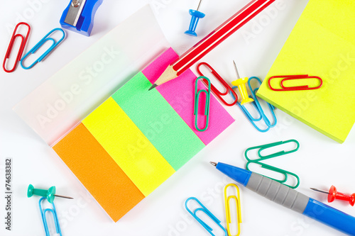 Multicolored office stationery on white desktop close up