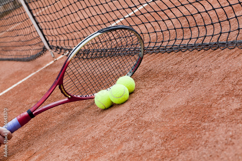 Close up of tennis racquet and balls on the clay tennis court  © pawel70