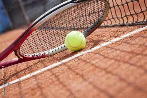 Close up of tennis racquet and ball on the clay tennis court  © pawel70
