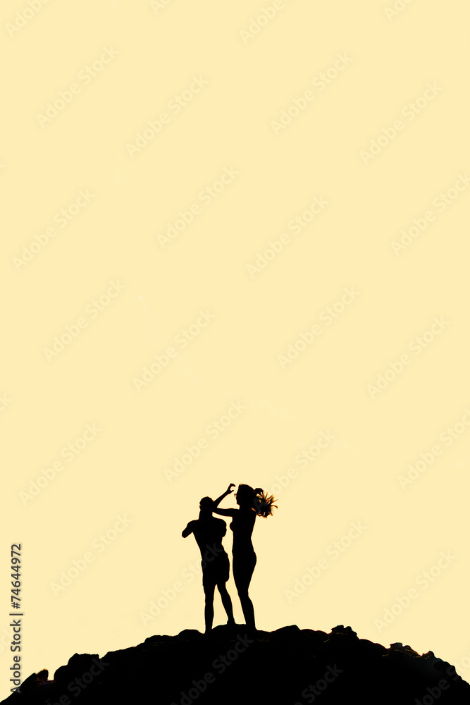 Naklejka premium Man and woman standing on mountain silhouette