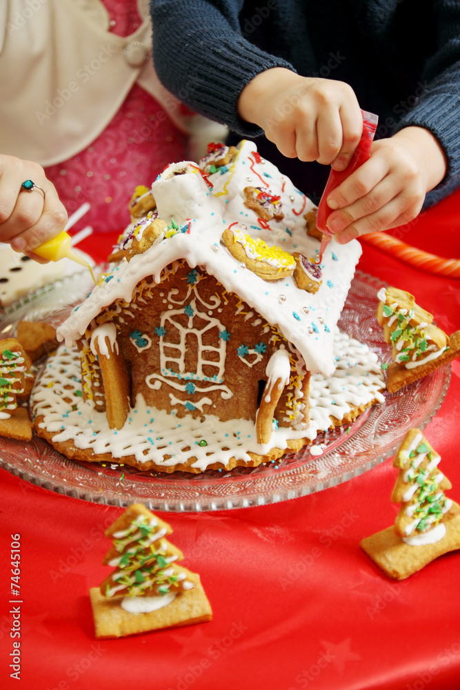 Fototapeta premium children decorate the gingerbread house