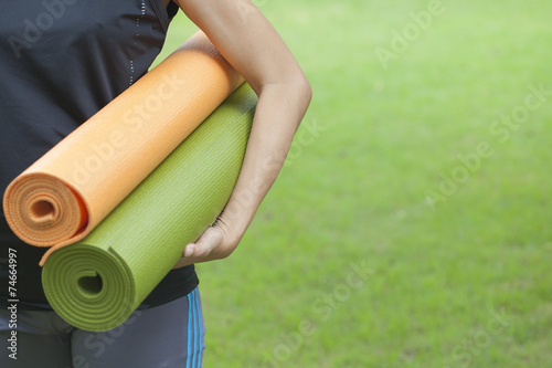 Young woman holding a yoga mats
