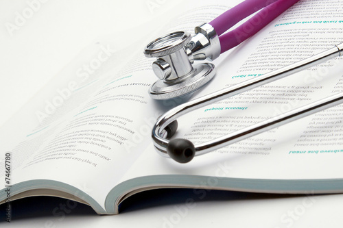 A medical stethoscope on an open book, closeup