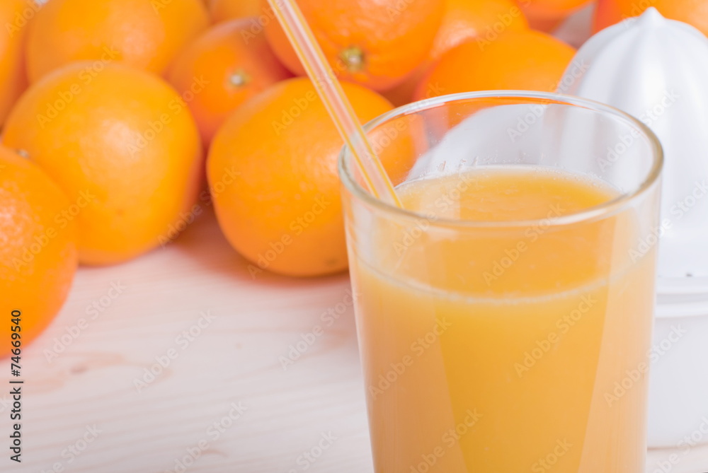 Orange fresh juice beside delicious ripe oranges on the table Orange fresh juice beside delicious ripe oranges on the table