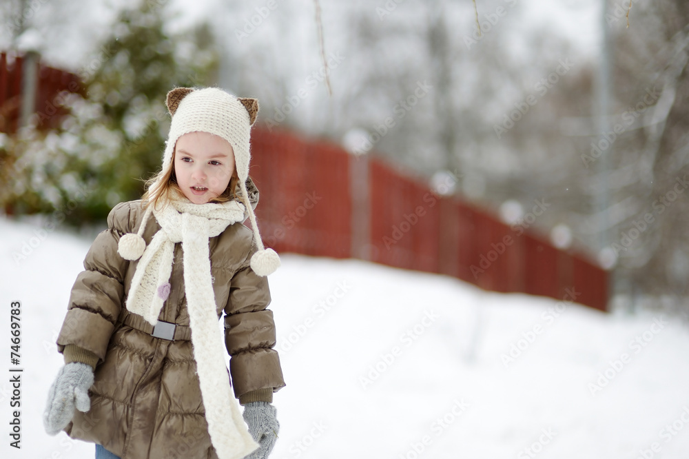 Obraz premium Adorable little girl having fun on winter day