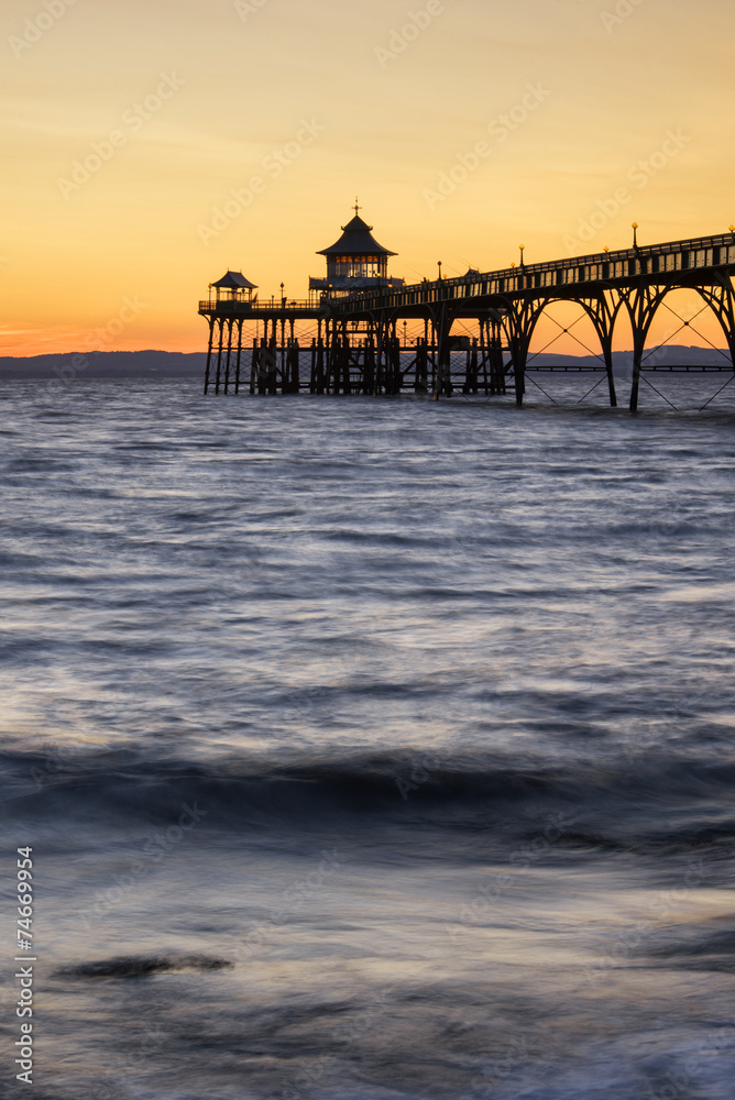 Beautiful long exposure sunset over ocean with pier silhouette