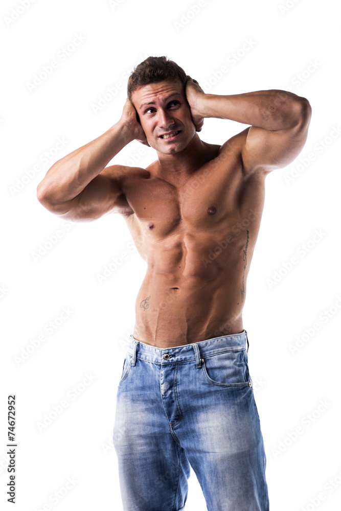 Irritated, frustrated, stressed muscle guy covering his ears