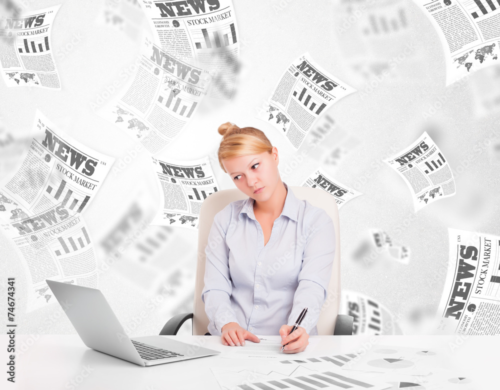 Business woman at desk with stock market newspapers Business woman at desk with stock market newspapers