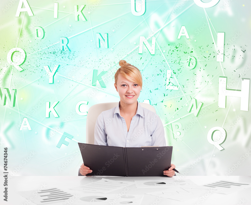 Business woman at desk with green word cloud Business woman at desk with green word cloud