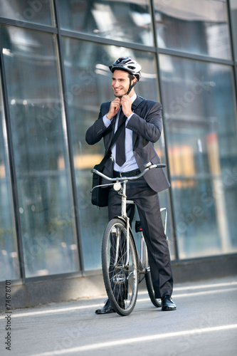 Businessman puts the bicycle helmet on head