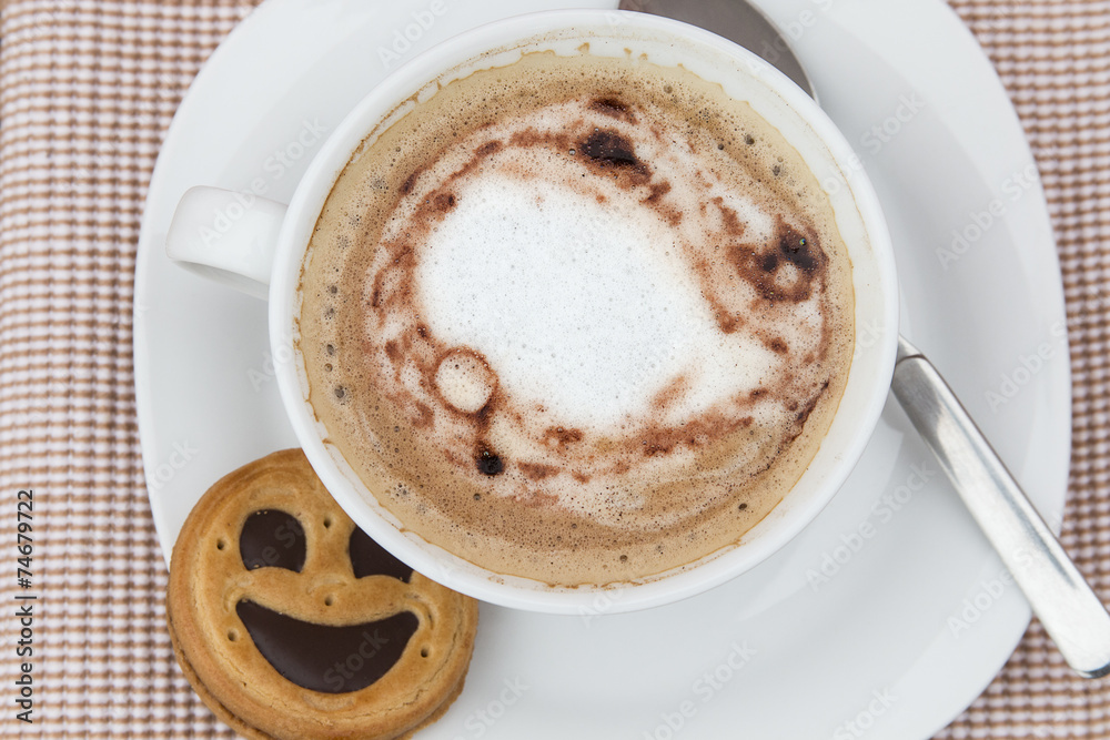 Cup of cafe au lait with smiling cookies Cup of cafe au lait with smiling cookies