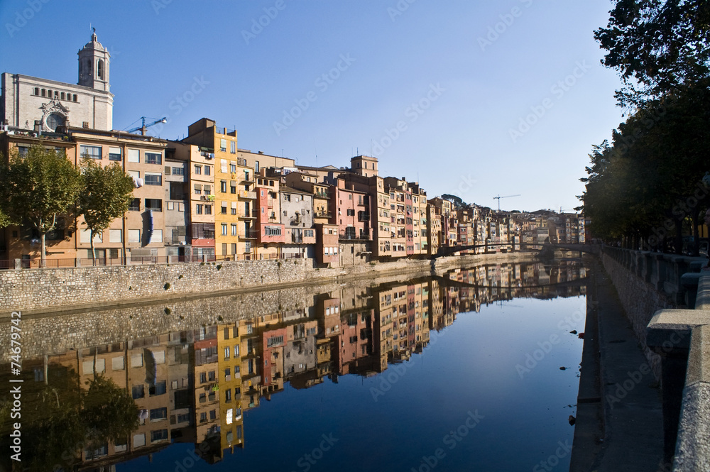 View Girona city  with colorful houses reflected in water of ony