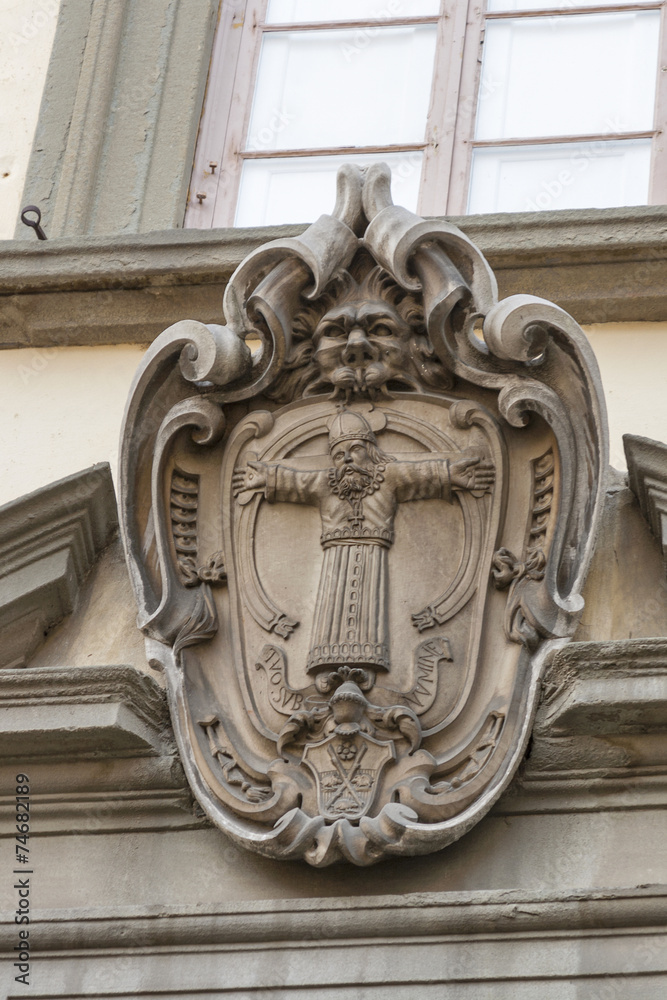 Stone old coat of arms on building wall in Lucca, Italy