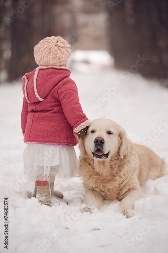 Little girl with dog at winter park
