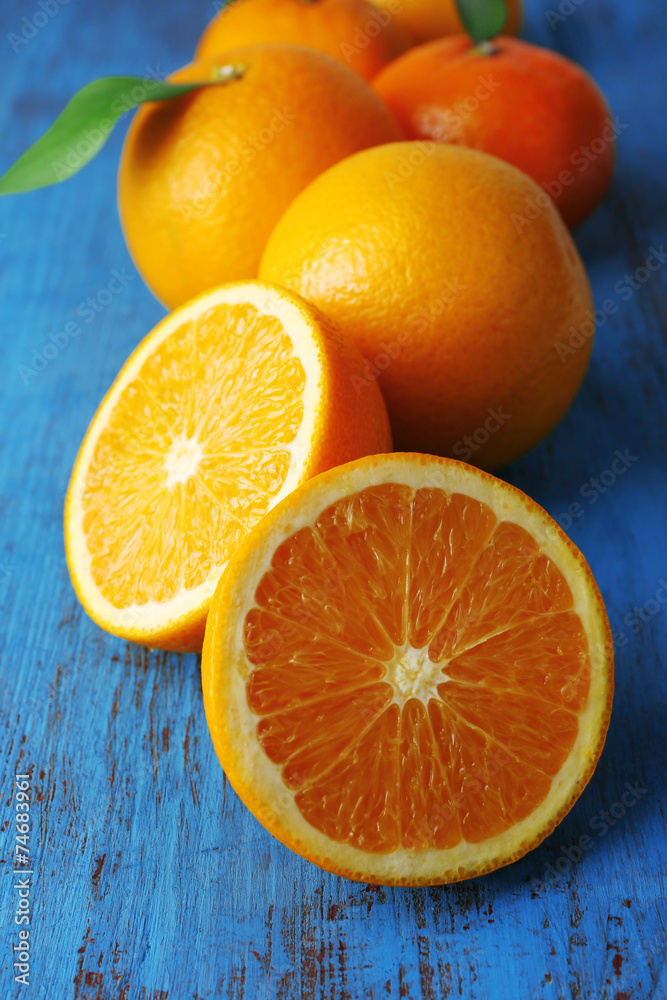Ripe tangerines and oranges with leaves on wooden background Ripe tangerines and oranges with leaves on wooden background