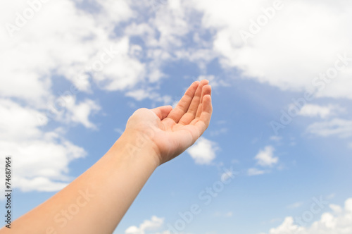Empty hand palm on the blue sky with clouds