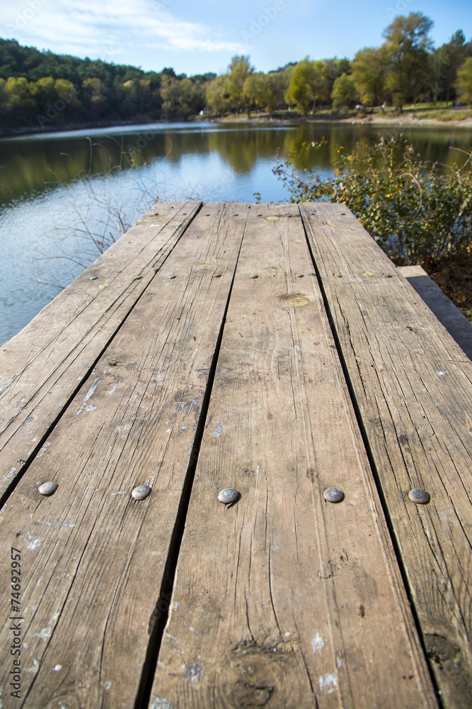 Perspective of wooden picnic table with blur landscape Perspective of wooden picnic table with blur landscape