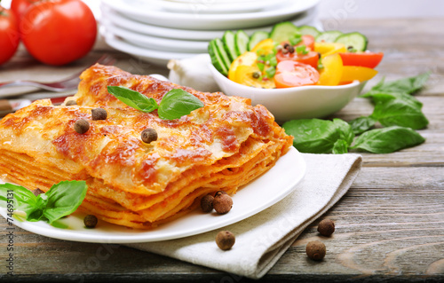 Portion of tasty lasagna on wooden table