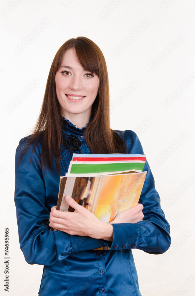 Young girl standing with a stack of magazines Young girl standing with a stack of magazines