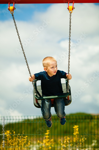 Little boy having fun at the playground. Child kid on swing
