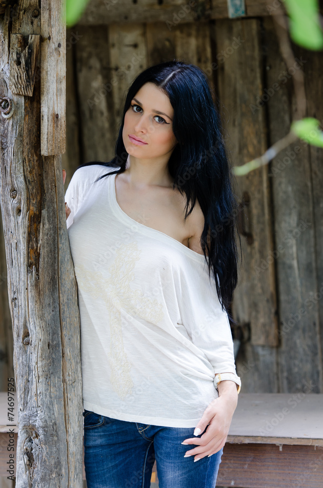 Fototapeta premium Beautiful woman front of wooden old house