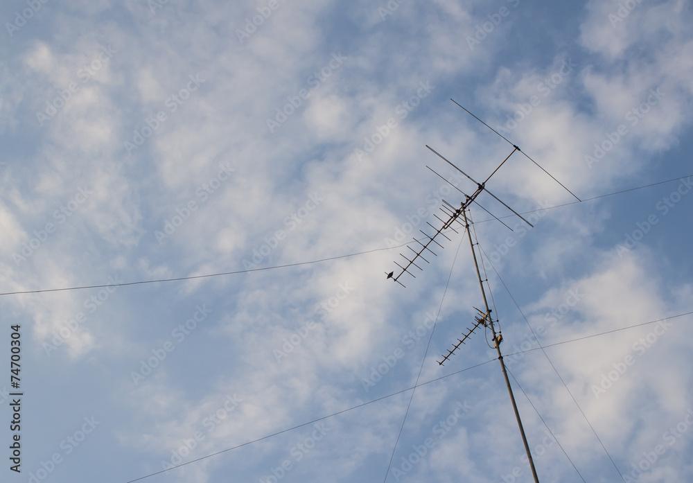 Old television antenna on blue sky background Old television antenna on blue sky background