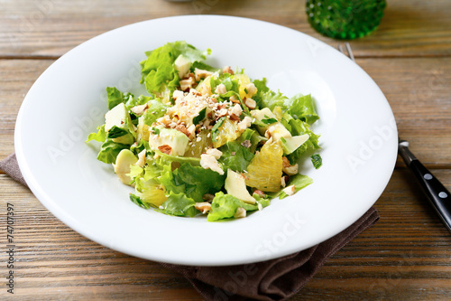 Fresh salad with avocado, orange and crushed nuts on a bowl