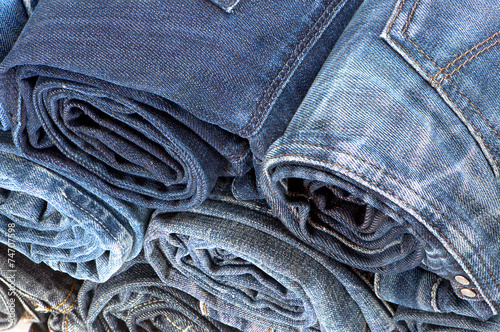Stack of rolled colored jeans. Top view